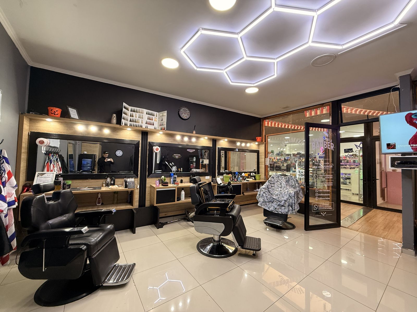 Interior de California Barber Coihueco: sillones de barbero e iluminación hexagonal